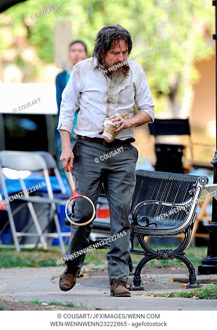 Bryan Cranston looks homeless and unrecognizable in dirty clothes and thick mustache as he sits lonely in a park bench begging for food for his new movie...