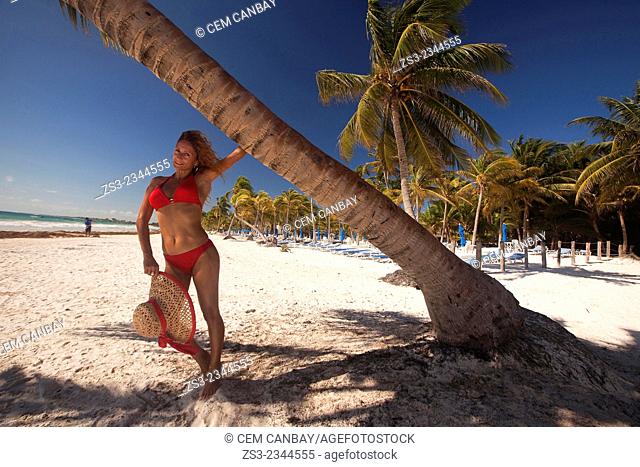 Woman posing near the tree at the beach, Tulum, Quintana Roo, Yucatan Province, Mexico, Central America
