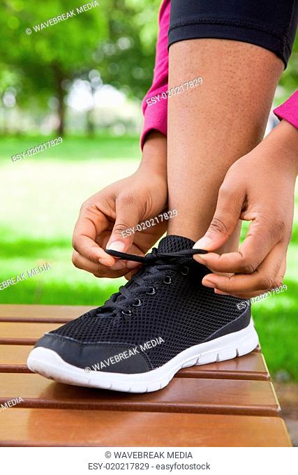 Woman tying her shoelace on running shoe