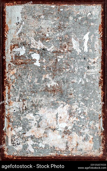 Texture of a grungy wall with torn posters and rusty frame. Ideal for textures and backgrounds. Retro style