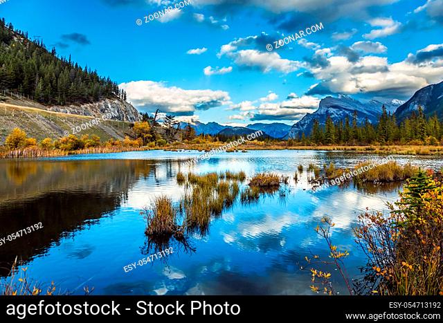 Autumn day on the lake Vermilion. Lush cumulus clouds are reflected in the smooth water of the lake. The concept of ecological, photographic and active tourism