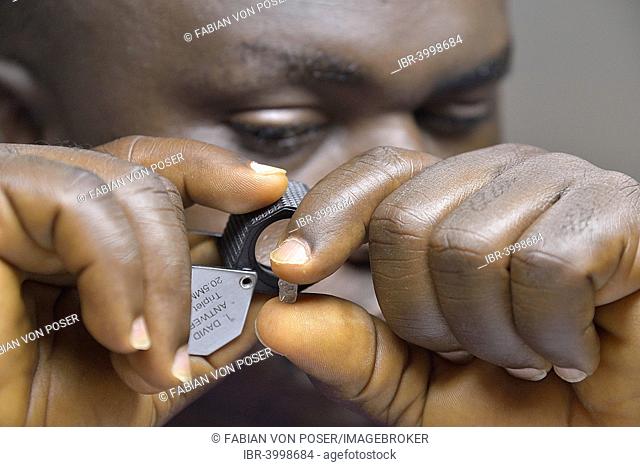 Diamond dealer looking at a diamond through a magnifying glass, Koidu, Koidu-Sefadu, Kono District, Eastern Province, Sierra Leone