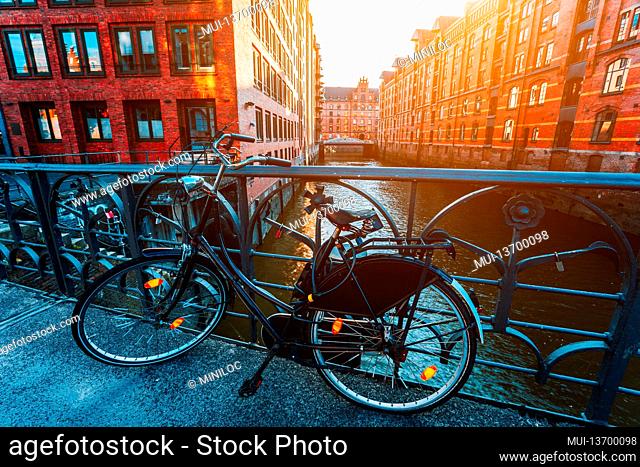Old bicycle parked against iron hand railing on bridge in Hamburg warehouse district
