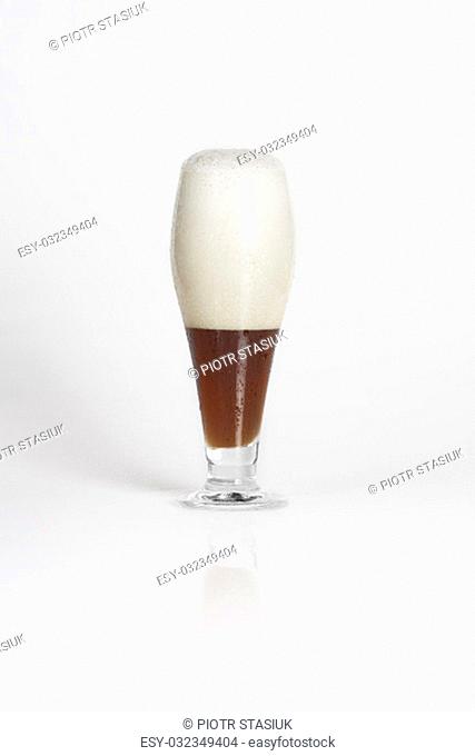 Half of glass of cold dark beer on a white background isolated