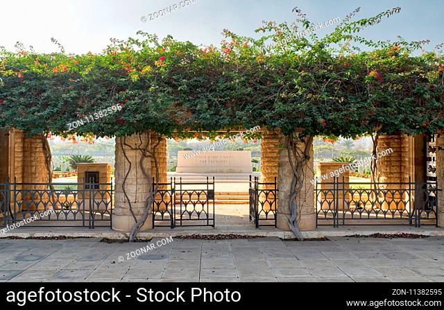 Cairo, Egypt - December 7, 2016: Entrance of Heliopolis Commonwealth War Cemetery with fence metal door, climber green plants