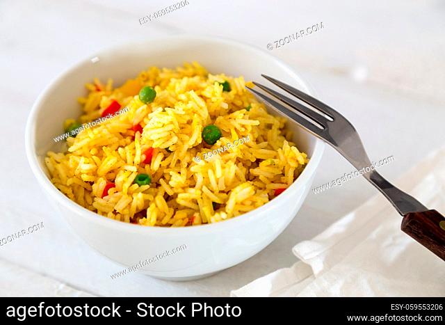 Curryreis in einer Schale auf weißem Holztisch