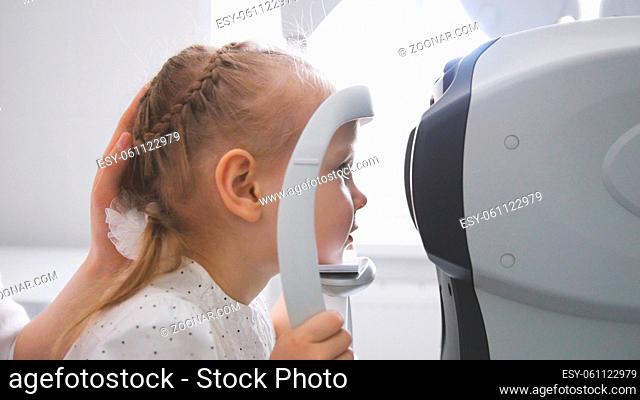 Children ophthalmology - optometrist Checks Child's Eye, telephoto