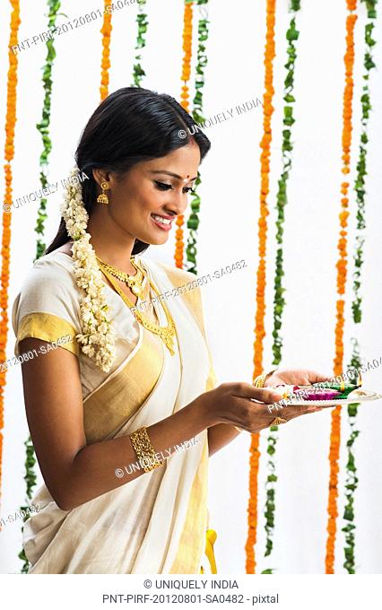 South Indian woman holding a puja thali at Onam