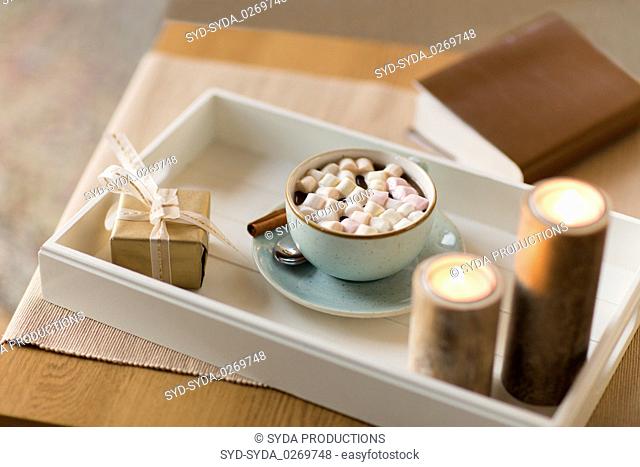 hot chocolate, christmas gift and candles on table
