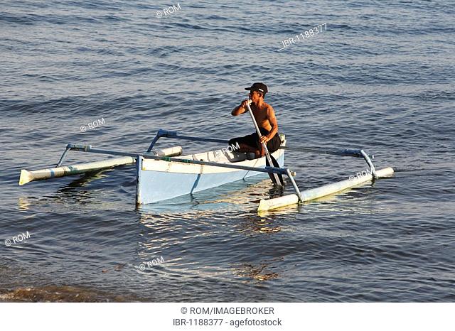 Fisherman coming home in an outrigger canoe, Balikpapan, East Kalimantan, Borneo, Indonesia