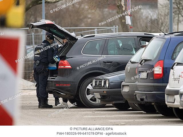 26 March 2018, Germany, Stuttgart: Police officers inspecting a car at the court before the start of the trial against alleged leader of the Turkish nationalist...