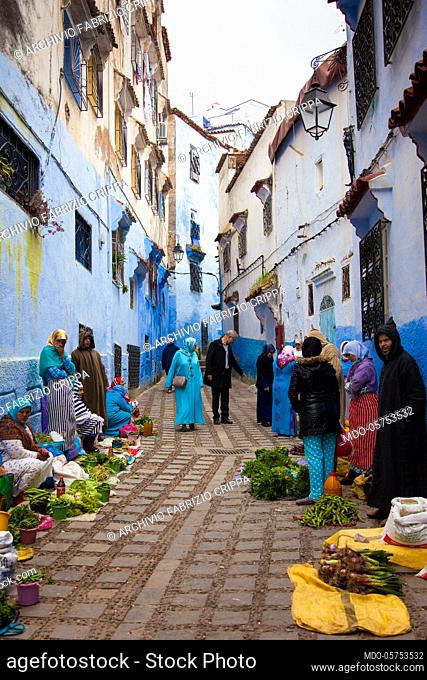 Women and men sell the products of their earth, fruit and vegetables, to the market in a street of Chefchaouen, April 2018