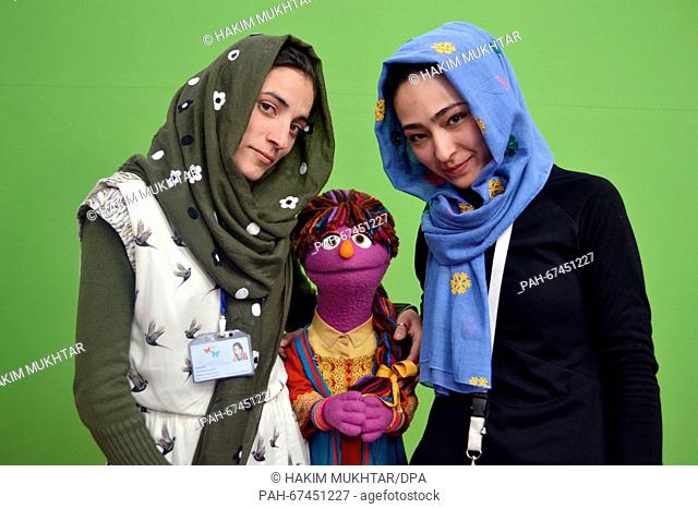 Puppeteers Mansura Schirsad (R) and Sima Sultani stand with the puppet 'Zari' in a studio from the Moby Group in Kabul, Afghanistan, 10 April 2016