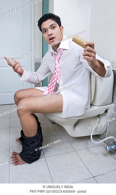 Man sitting on a toilet and gesturing