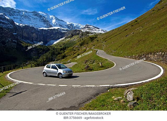 Car in a hairpin curve, mountain road to the Klausen Pass in front of the Glarus Alps, Urnerboden, Canton of Uri, Switzerland
