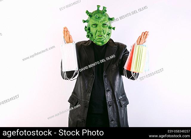 Person disguised as a coronavirus with a latex mask - covid-19 virus, wearing a black leather frock coat and a black t-shirt