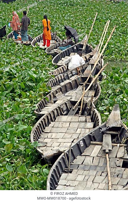 People are crossing Buriganga river by a makeshift bridge made of boats in Kamrangir Char, in Lalbagh area of Old Dhaka Usually boats are used to ferry people...