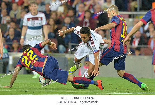 Barcelona's Dani Alves (L) and Javier Mascherano (R) vie with Munich's Thiago Alcantara (C) for the ball during the UEFA Champions League semi-final first leg...