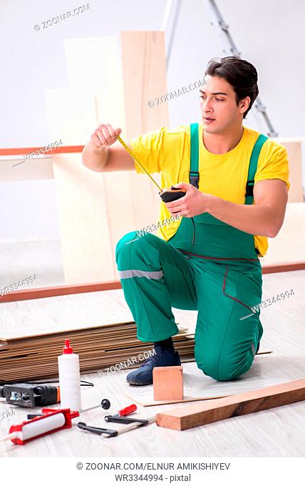 Contractor working on laminate wooden floor