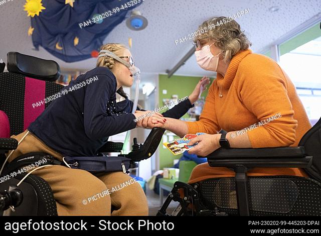 11 January 2023, Hesse, Wiesbaden: In the living area of the ""Bärenherz"" children's hospice, Jeanette Ott (r) plays with her daughter Catherine