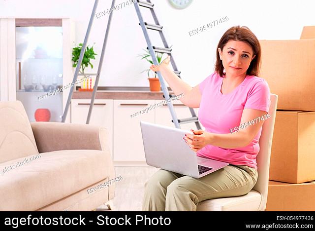Middle-aged woman with laptop in home improvement concept