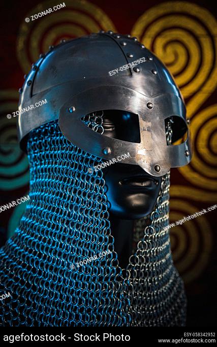 Traditional Vikings, viking helmet with chain mail on a red shield with golden shapes of sun, weapons for war