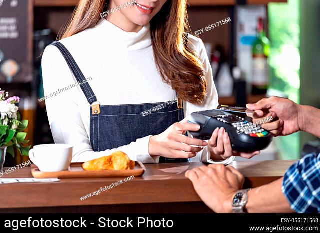 Asian customer using contactless credit card nfs technology pay to barista at cafe bar. Contactless payment preventing from coronavirus covid-19 Spreading and...