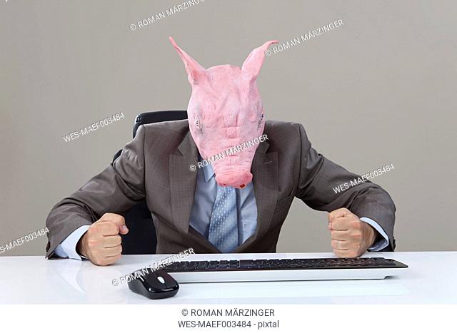 Close up of businessman with pigs head hitting table in office against grey background