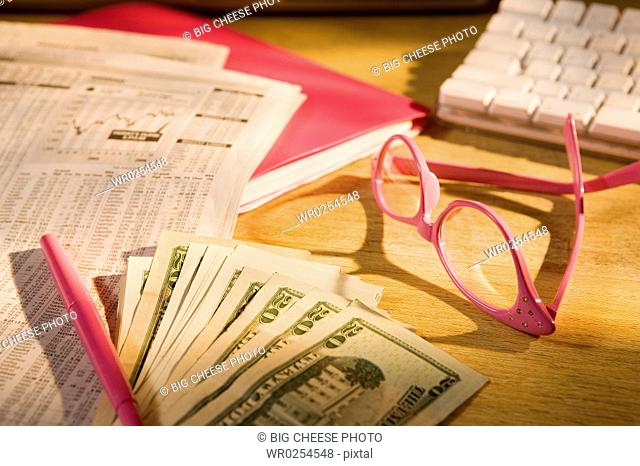 Glasses and money with newspaper