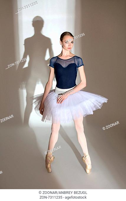 Full growth portrait of the graceful ballerina in a studio