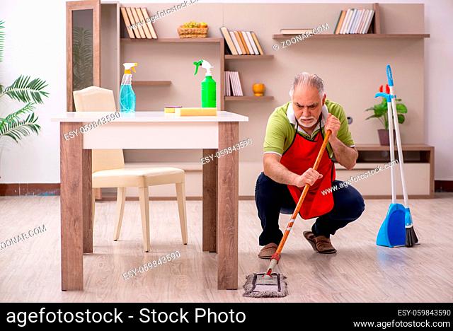 Aged man cleaning the house