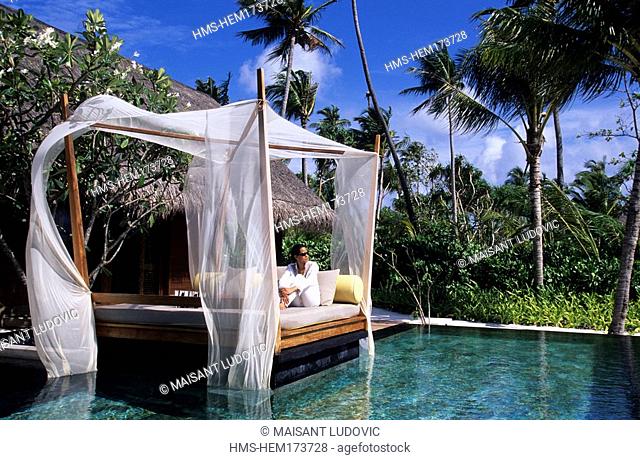Maldives, North Malé Atoll, One & Only Reethi Rah Hotel, girl relaxing on the edge of the private swimming-pool of her beach villa