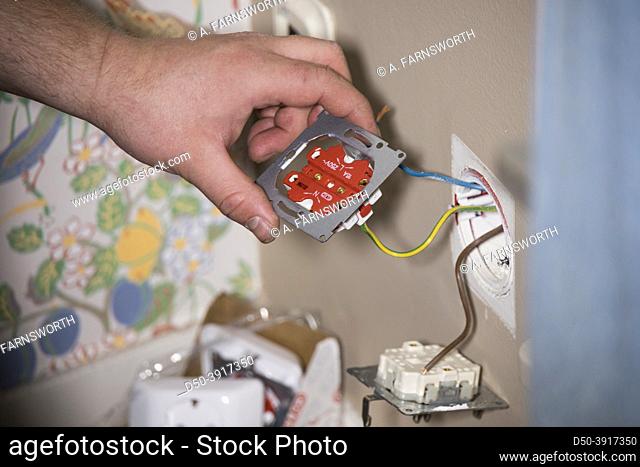 Stockholm, Sweden An electrician fixes wiring in a home
