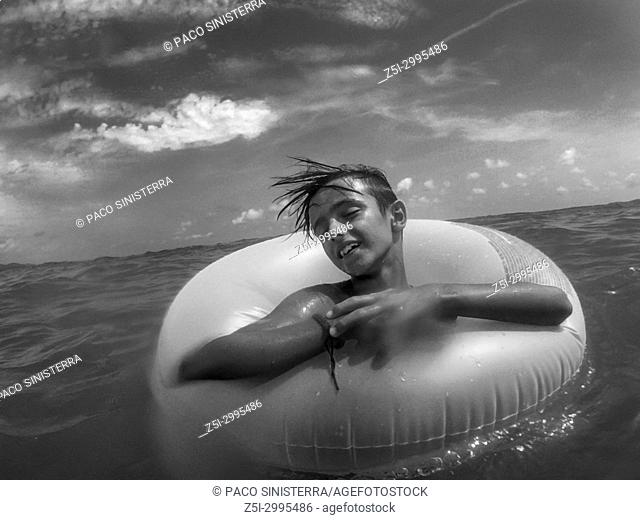 Young boy in float, relaxed in the sea, Oropesa, Spain