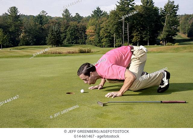 Pennsylvania, Pocono Mountains, Hawley, The Country Club at Woodloch Springs, golf course, male golfer, green, blowing ball, hole, humor