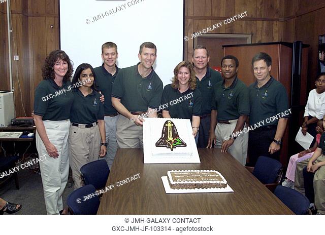 The STS-107 crewmembers, along with Stephanie Turner (center) of the United Space Alliance (USA), pause from their mission training for a cake cutting ceremony...