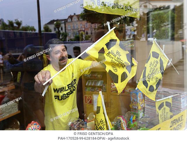Shop owner Recep Yalniz decorates the display window of his shop Muskara with little flags with the wording 'Wir sind alle am Borsigplatz geboren' (lit