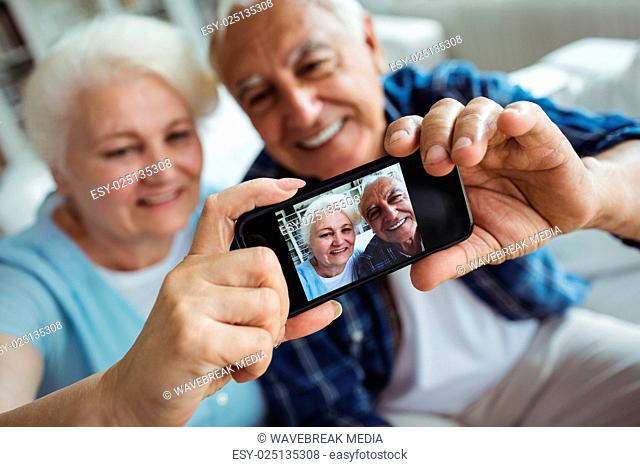 Senior couple taking a photo from mobile phone
