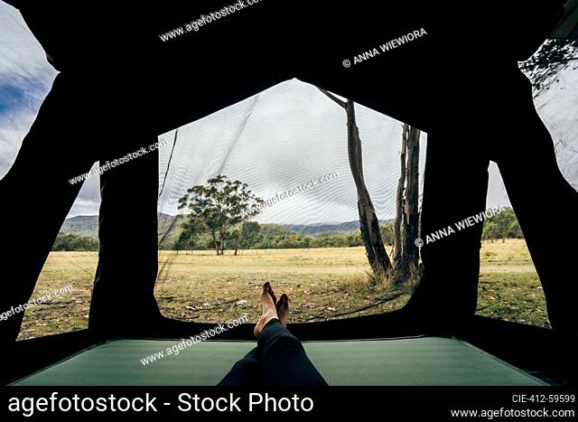 POV woman relaxing inside tent in remote Australian bush