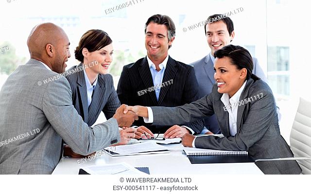 Happy business people closing a deal in a meeting