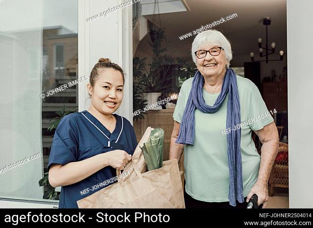 Home carer and senior woman looking at camera