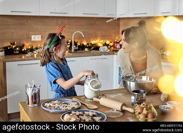 Happy mother and daughter enjoying baking time in kitchen