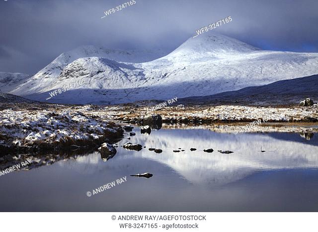 Snow covered peaks reflected in the River Ba' on the southern edge of Rannoch Moor in the Scottish Highlands
