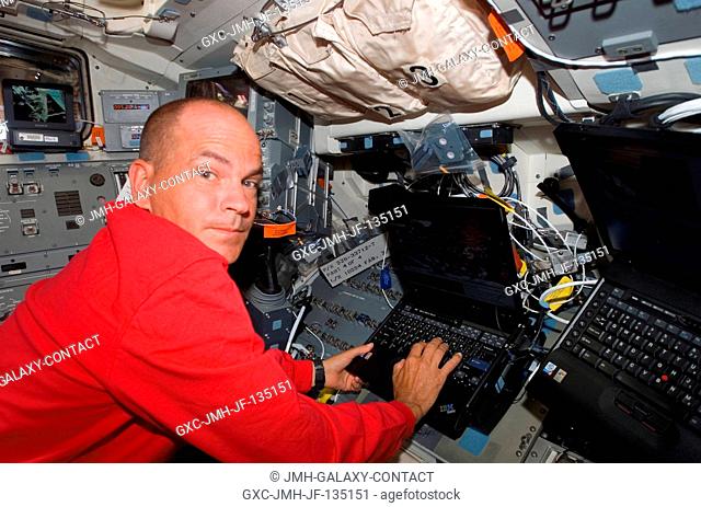 Astronaut Rick Sturckow, STS-117 commander, uses a computer on the flight deck of Space Shuttle Atlantis during flight day six activities while docked with the...