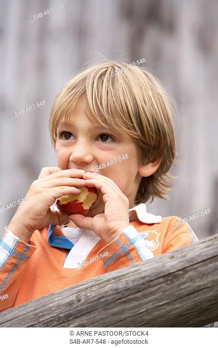 Boy is eating an apple, Austria, Europe