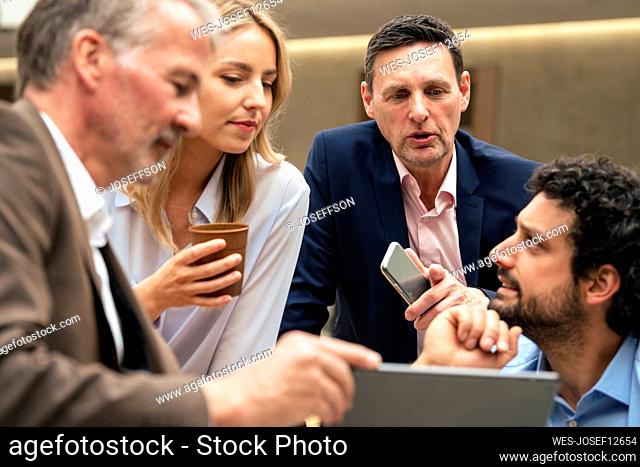 Business colleagues discussing strategy over tablet computer