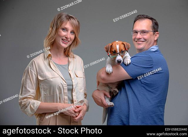 Happy woman and man in studio plays with jack russell terrier dog. Pet love concept