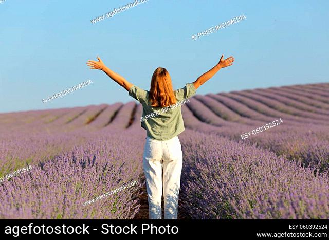 Back view of a lady celebrating vacation in lavender field