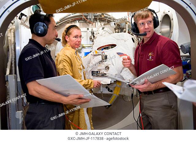 NASA astronaut Sandy Magnus, STS-135 mission specialist, prepares for an Extravehicular Mobility Unit (EMU) spacesuit fit check in the Space Station Airlock...