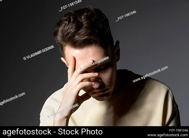 Tired young man with head in hands